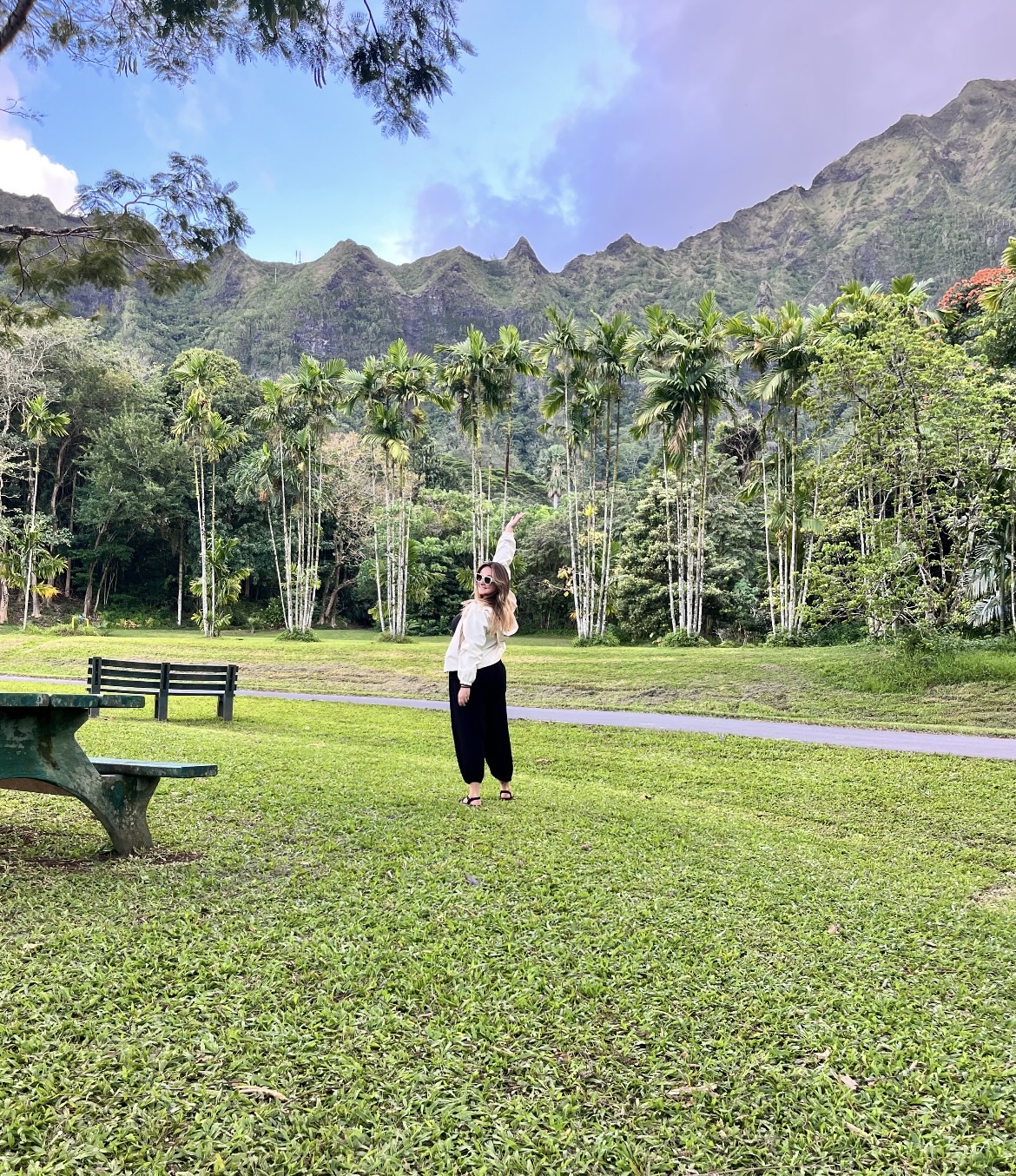 Emily Powers in a Hawaiian valley, palms and green ridgeline behind her