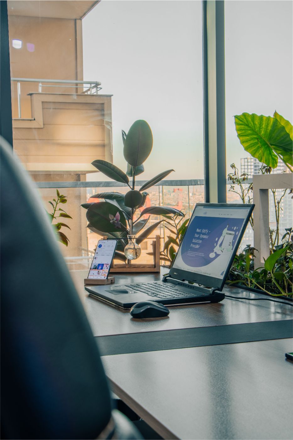 A plant-filled workspace with a laptop open